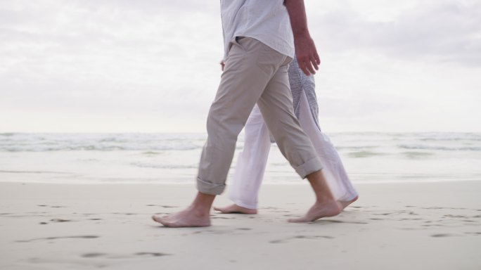 一对幸福的成年夫妇在海滩上放松散步的4k