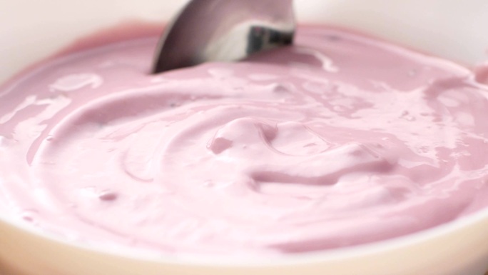 用勺子舀水果酸奶。
