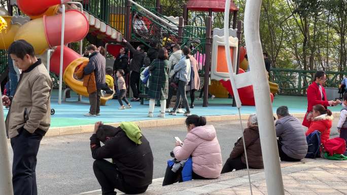 儿童乐园遛娃带娃的家长坐旁边看手机划手机
