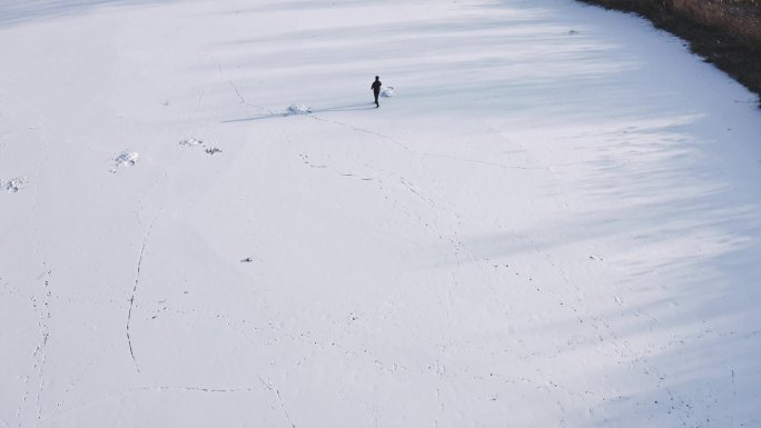 航拍一个人在雪地中孤单的行走