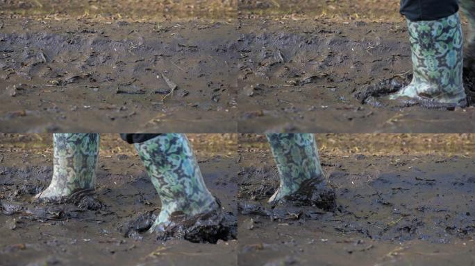 穿着橡胶靴在泥泞中行走的特写镜头