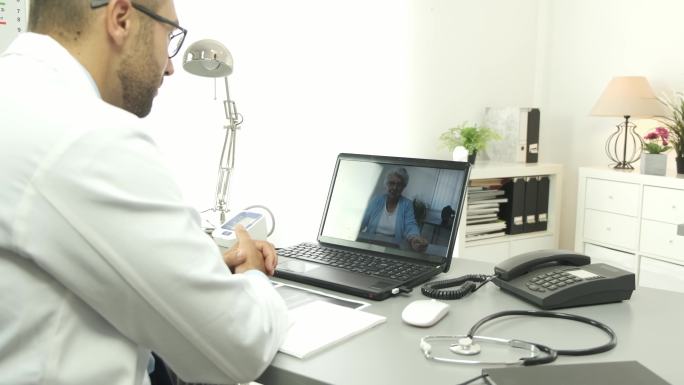 医生通过电脑与女患者进行远程医疗咨询