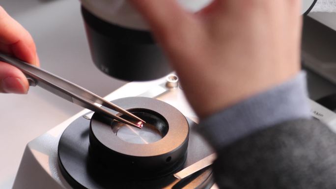 珠宝设计师通过显微镜对宝石的质量进行分级