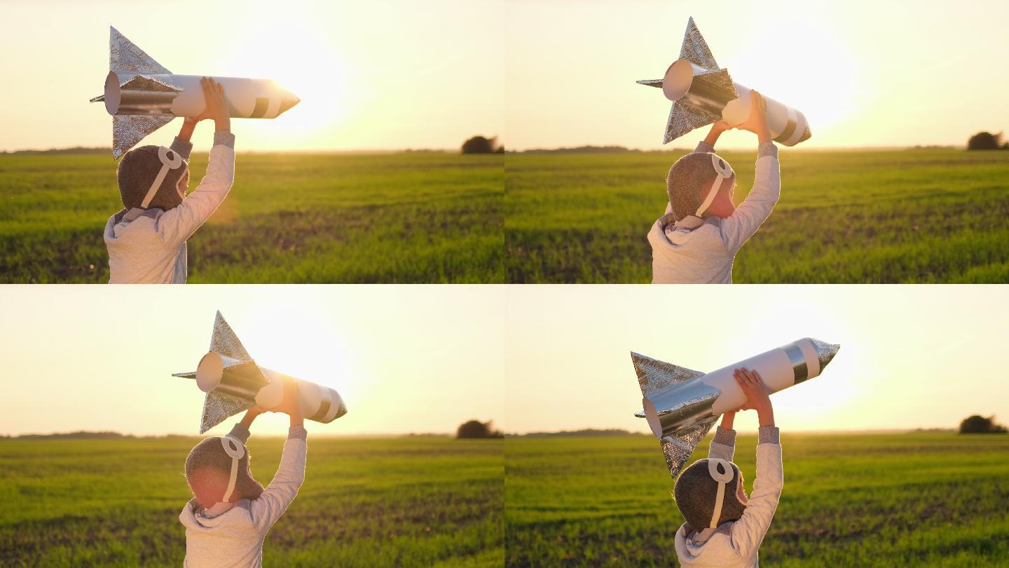 戴着头盔的小男孩在田野里玩火箭