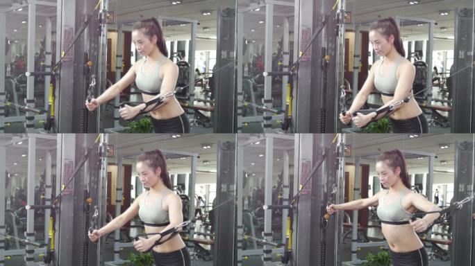 年轻女子在现代健身房体能训练拉力器健身