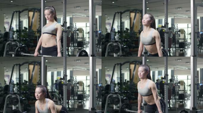 年轻女子在现代健身房杠铃力量体能训练