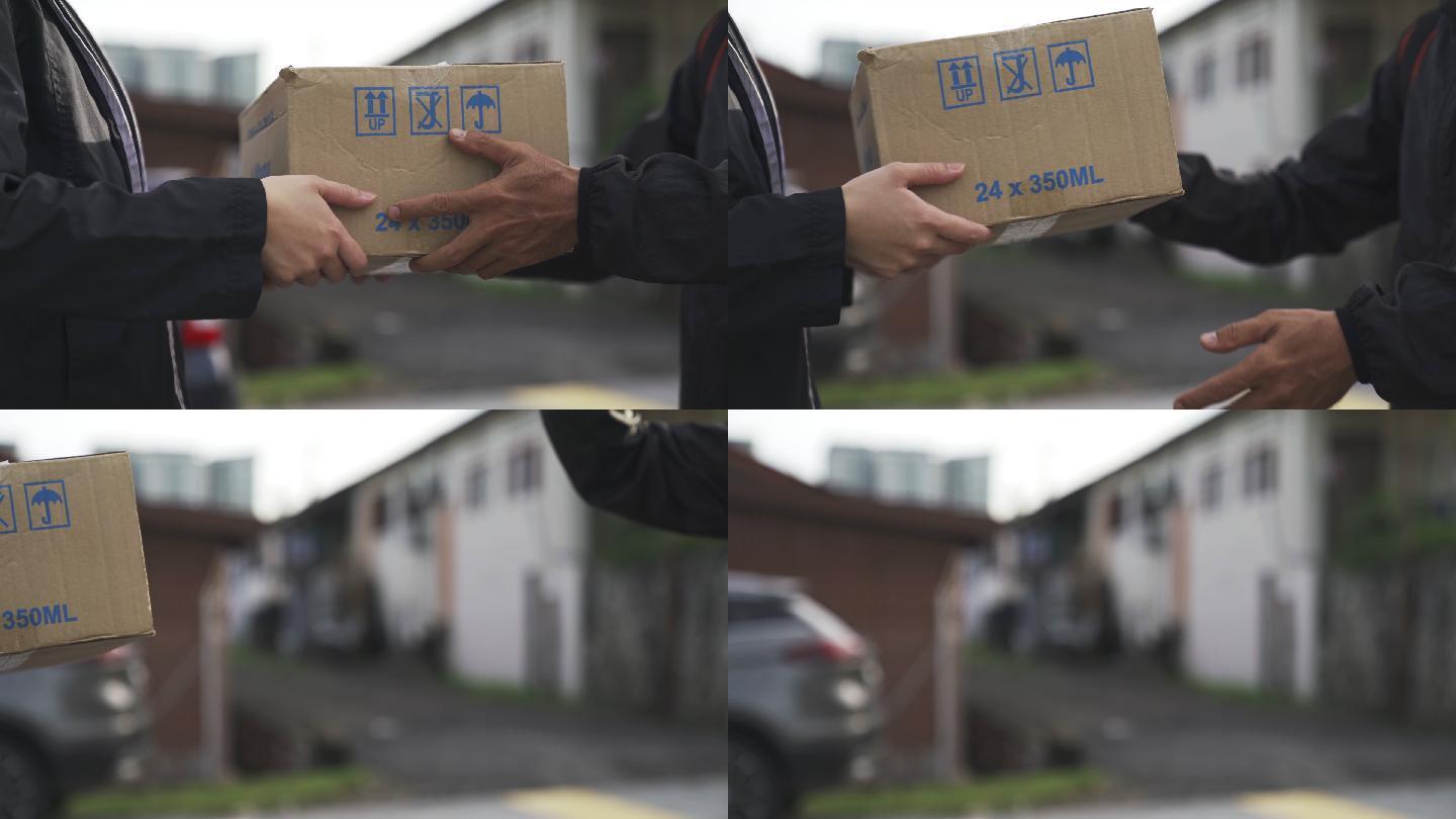 快递员将包裹纸箱递送给他的客户