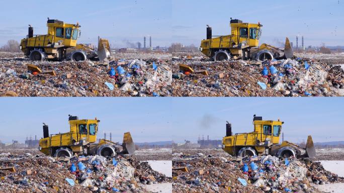 一辆垃圾填埋车将垃圾场的第一层垃圾整平。