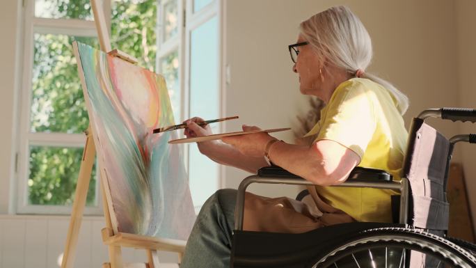 老年妇女坐在轮椅上画画