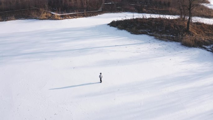 航拍一个人在雪地中孤单的行走