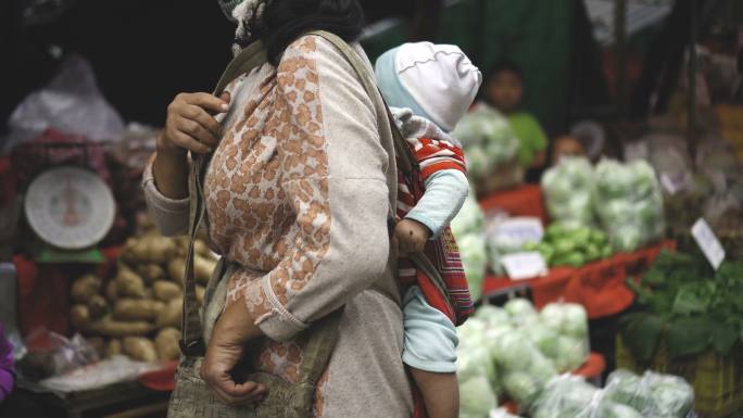 女人和婴儿菜市场买菜买东西育儿袋