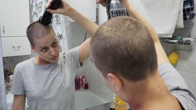 癌症患者在浴室修剪头发
