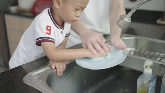 父亲正在教儿子如何洗碗