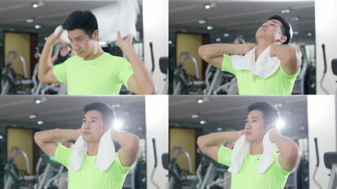 年轻男人在健身房健身体锻炼休息毛巾擦汗