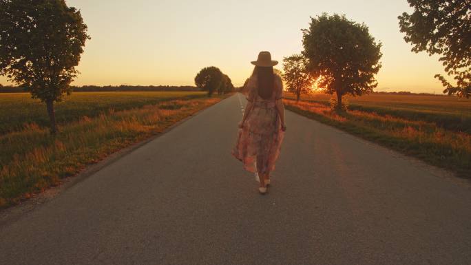 日落时分，女子走在空旷的路上