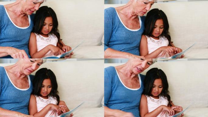 奶奶和孙女在客厅看相册时互动