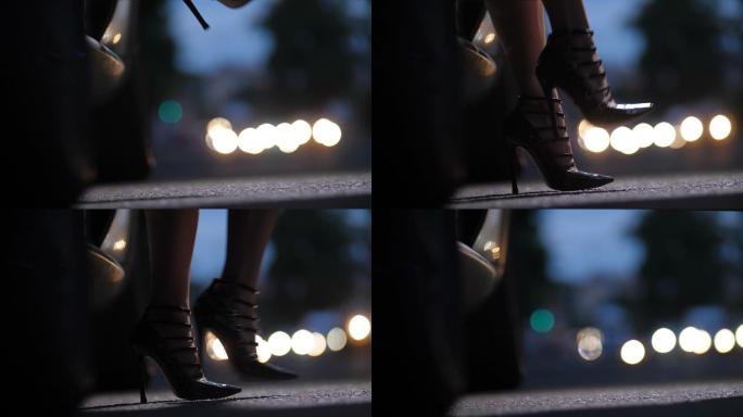 穿着高跟鞋的女人在晚上走出汽车