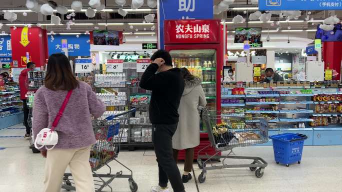 超市里顾客正挑选冰冻饮料两对恋人情侣路过