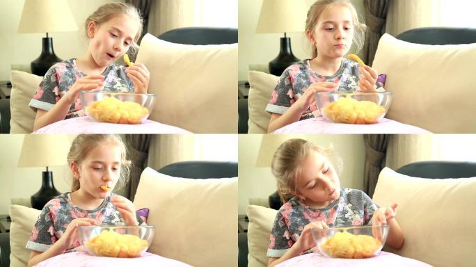快乐的小女孩在吃薯片