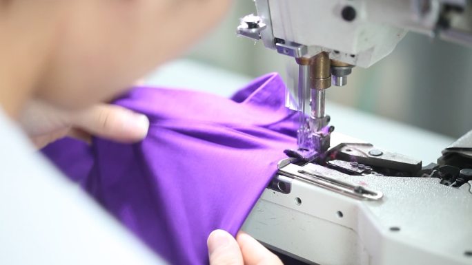 现代制衣厂制衣车间缝纫工人缝纫机器衣服