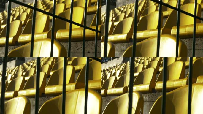 体育场里，金属栅栏后面的黄色椅子