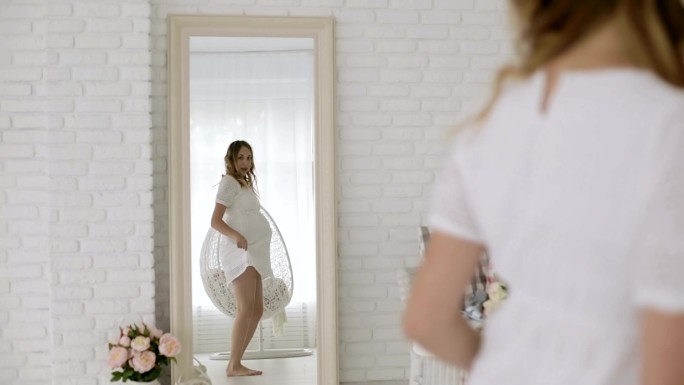 年轻孕妇在镜子前尽情跳舞