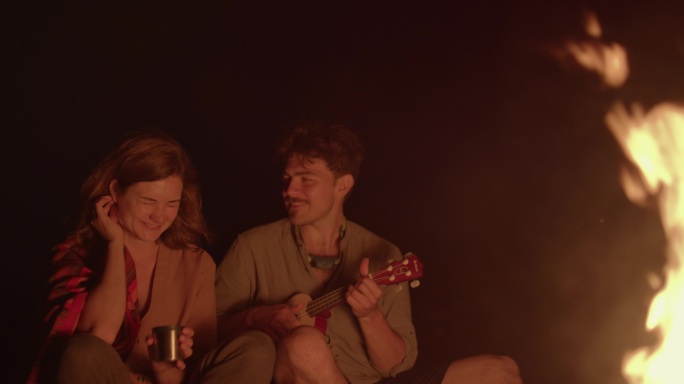 男子篝火旁为女友弹吉他