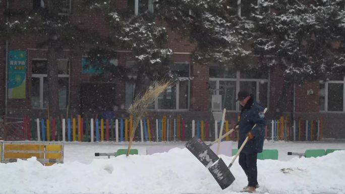 雪中清理校园积雪的保安大爷