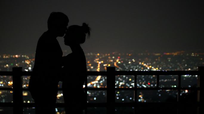 年轻情侣在城市背景下接吻