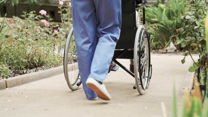 护士推着轮椅上的老人散步