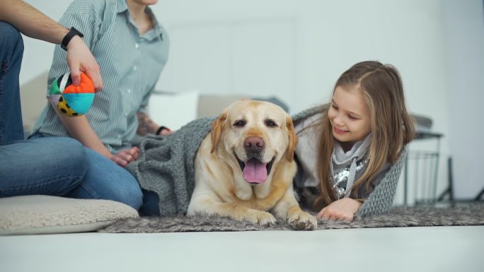 少女躺在地毯上抚摸她的狗