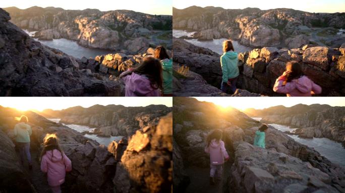 两个小女孩在多岩石的海滨玩耍。