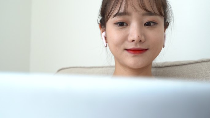 看着笔记本电脑屏幕的年轻亚洲女性