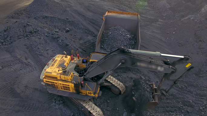 挖掘机把煤装进自卸卡车