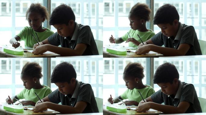 小女孩和男孩在课堂上用蜡笔涂色
