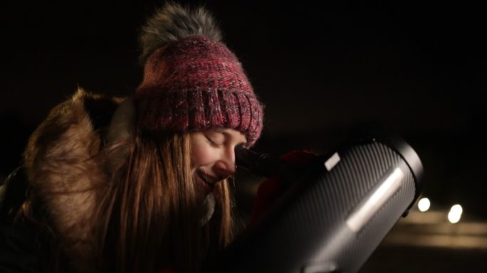 少女用望远镜观察夜空