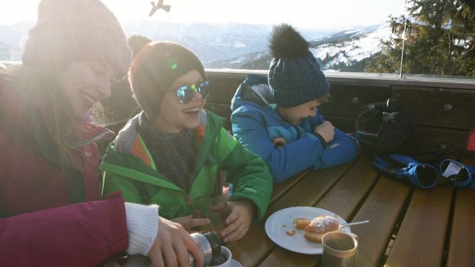 小滑雪者在阿尔卑斯滑雪酒吧吃午餐