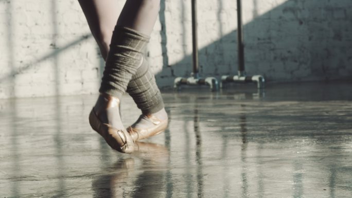 芭蕾舞工作室中的舞者踮着脚尖保持平衡