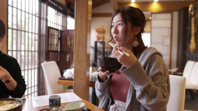 年轻女性在日本餐厅吃日本食品