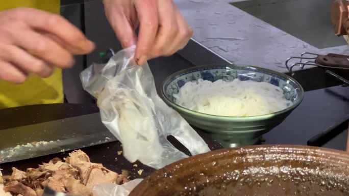 一碗桂林卤菜粉厨师戴手套准备加料