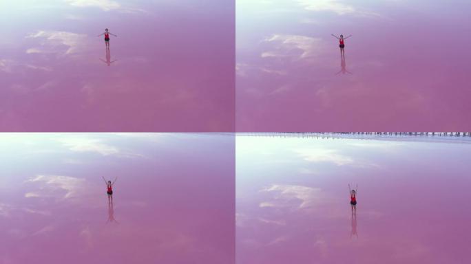 粉色盐湖上一名女子做瑜伽的鸟瞰图