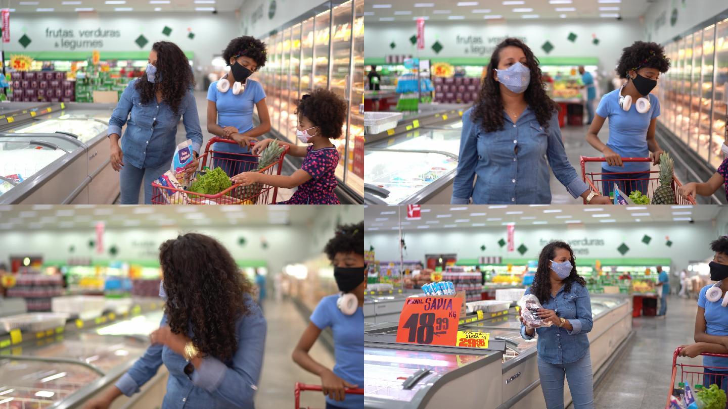 母亲和女儿戴着口罩在超市买冷冻食品