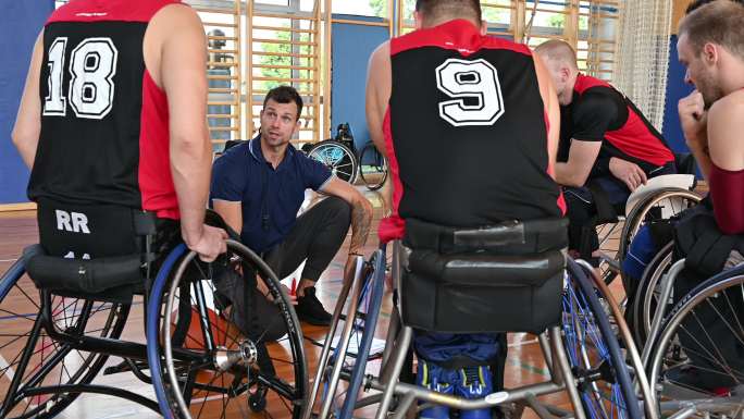 教练在健身房激励轮椅篮球运动员