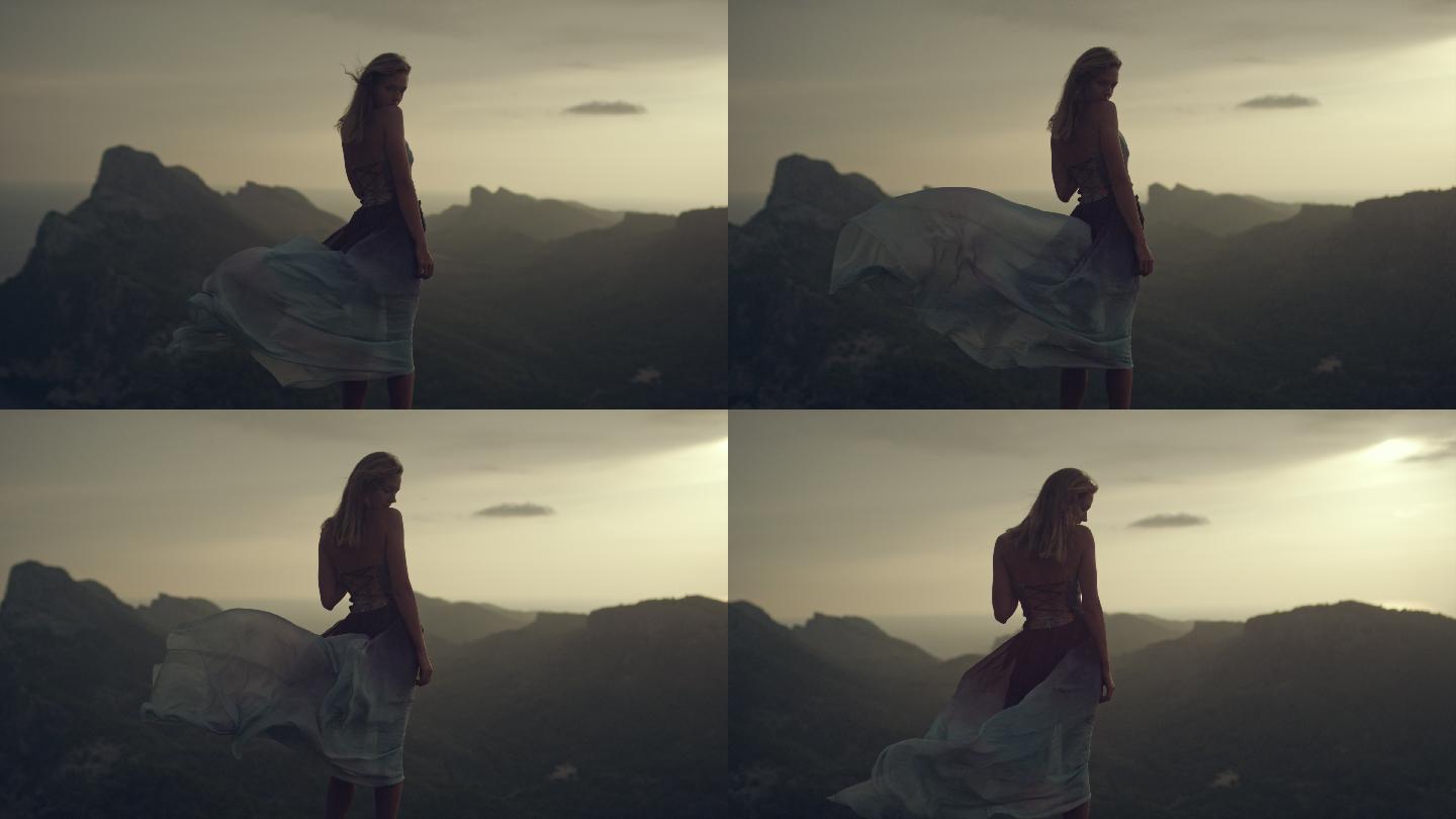 穿着夏日长裙的年轻女子站在悬崖上