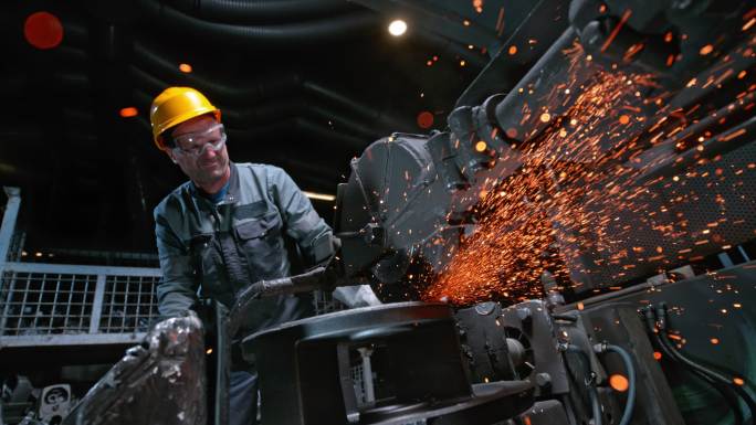在铸造厂给钢铁切割的男工人