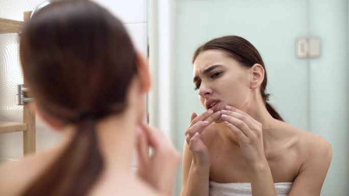 年轻女性在浴室挤粉刺