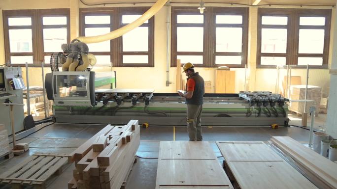 木工在木材厂，使用数字平板电脑