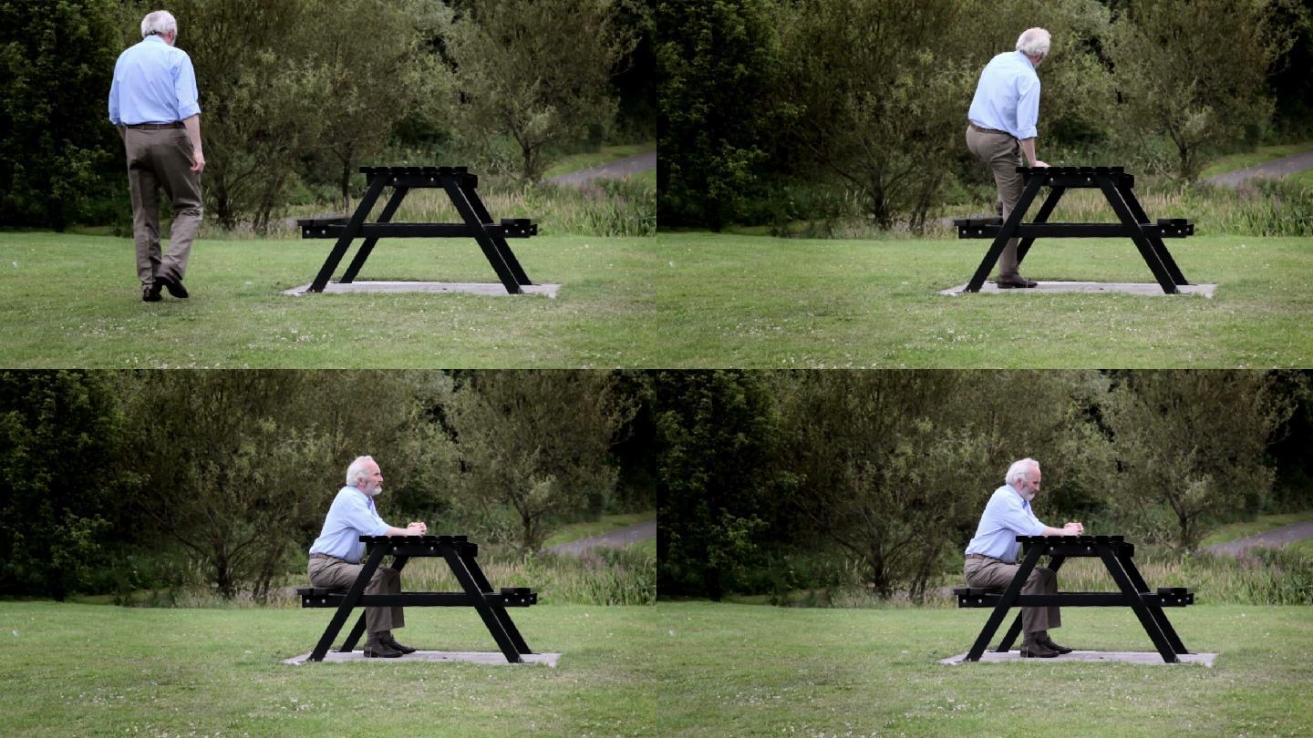 一位老人走到公园的野餐桌旁