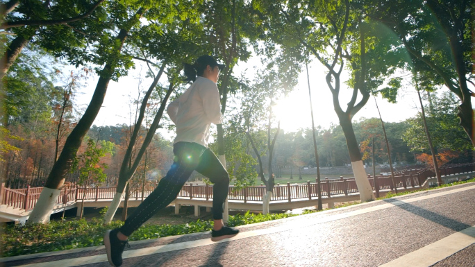 励志女孩在阳光下的公园绿道跑步视频素材