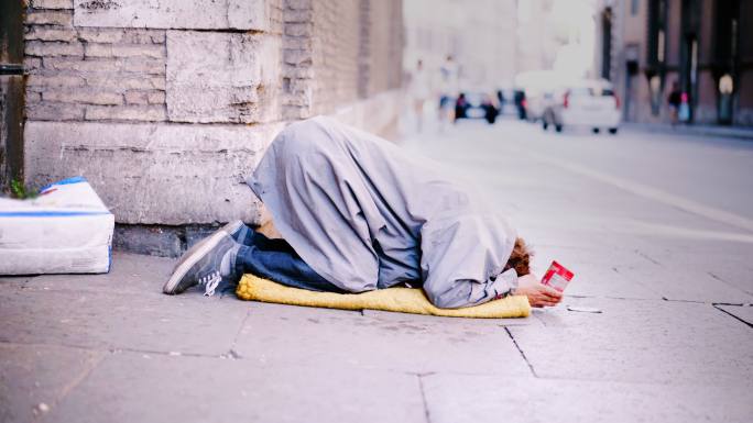 无家可归的男子跪在地上乞讨